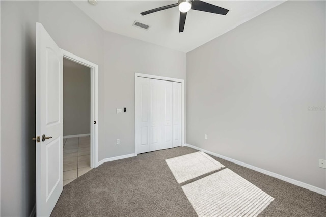 unfurnished bedroom with ceiling fan, carpet, and a closet