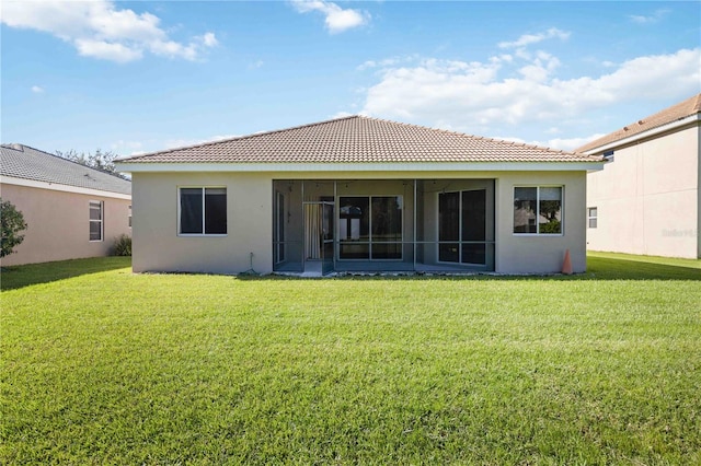 back of property with a yard and a sunroom