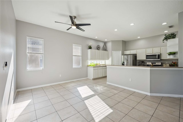 kitchen with ceiling fan, light tile patterned flooring, white cabinets, and appliances with stainless steel finishes