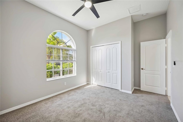 unfurnished bedroom featuring light carpet, ceiling fan, and a closet