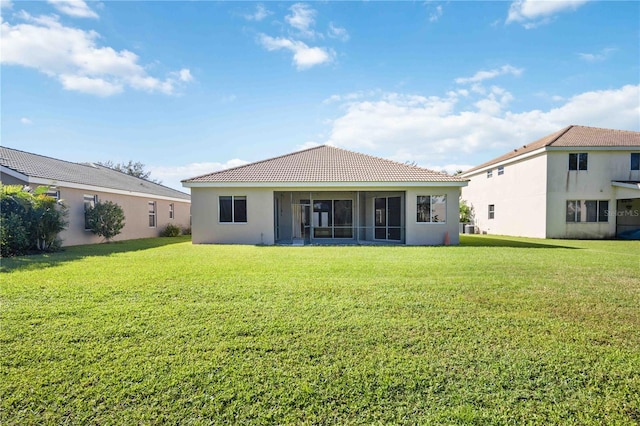 back of house featuring a lawn and a sunroom