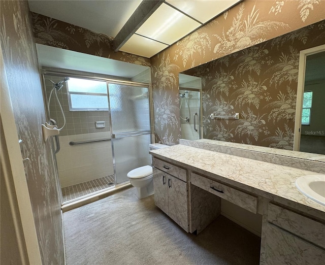 bathroom featuring vanity, a shower with shower door, and toilet