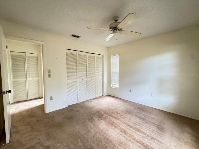 unfurnished bedroom featuring carpet floors, a textured ceiling, ceiling fan, and a closet