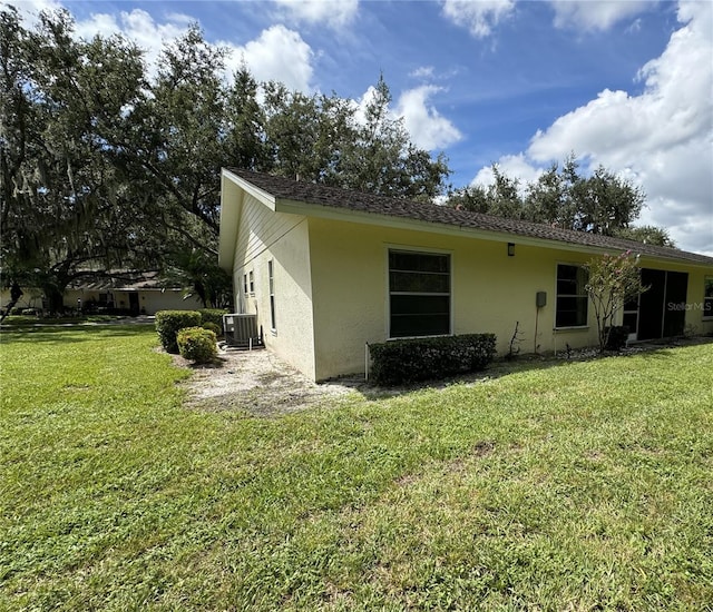 rear view of property with a yard and central AC