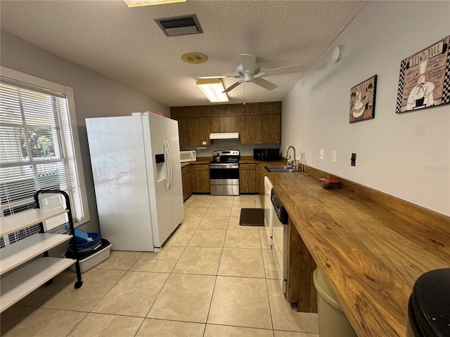 kitchen featuring ceiling fan, a textured ceiling, light tile patterned floors, and white appliances