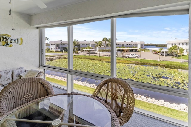 sunroom / solarium featuring a residential view and a water view