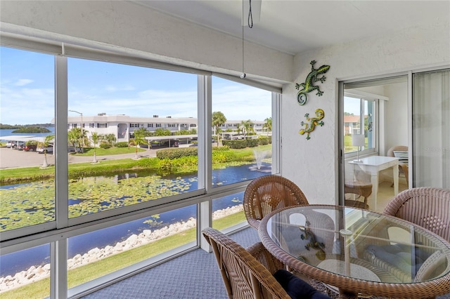 sunroom / solarium featuring a wealth of natural light and a water view