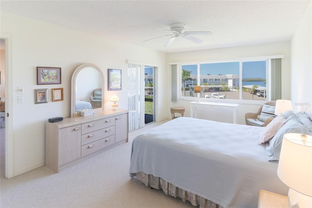 bedroom with access to outside, a ceiling fan, a textured ceiling, and light colored carpet