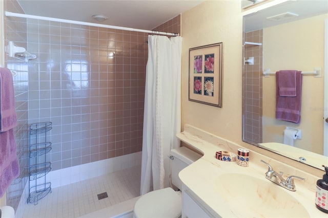 bathroom featuring visible vents, vanity, a tile shower, and toilet