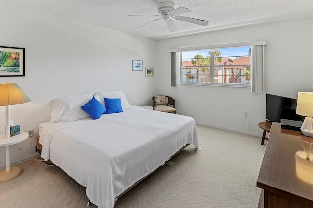 carpeted bedroom featuring a ceiling fan, a textured ceiling, and baseboards