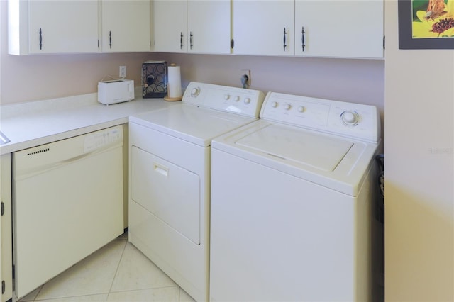 laundry room with laundry area, washing machine and dryer, and light tile patterned floors