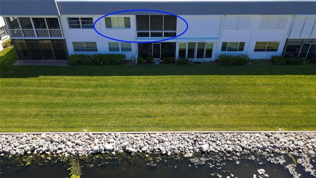 back of house featuring a water view and a yard