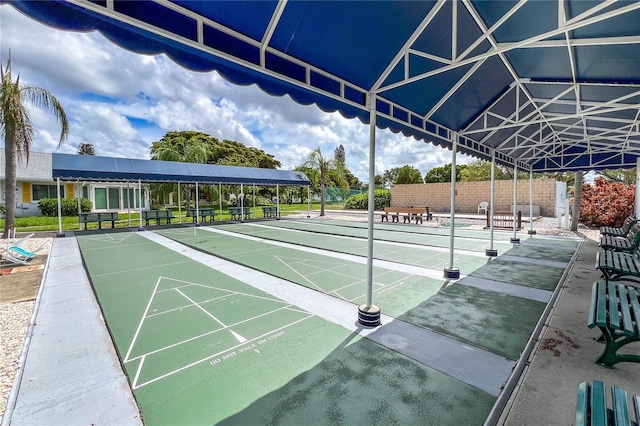 view of property's community with fence and shuffleboard