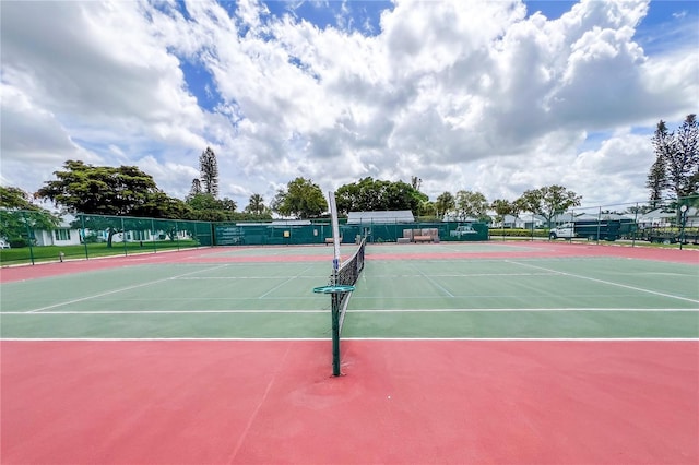 view of tennis court with community basketball court and fence