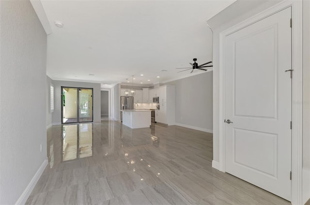 unfurnished living room featuring sink and ceiling fan with notable chandelier