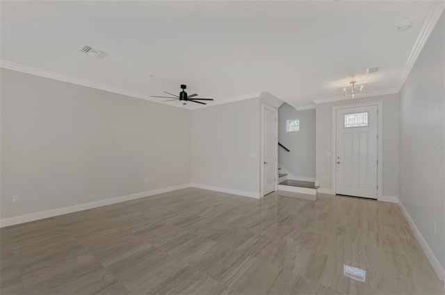 foyer featuring crown molding, ceiling fan with notable chandelier, visible vents, stairway, and baseboards