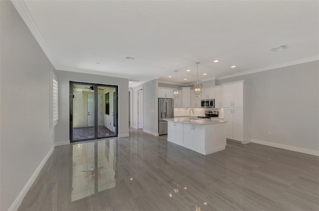 kitchen featuring a kitchen island with sink, pendant lighting, french doors, appliances with stainless steel finishes, and white cabinets