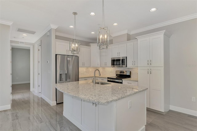 kitchen featuring white cabinets, stainless steel appliances, an island with sink, and sink