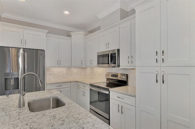 kitchen featuring ornamental molding, stainless steel appliances, white cabinetry, and sink