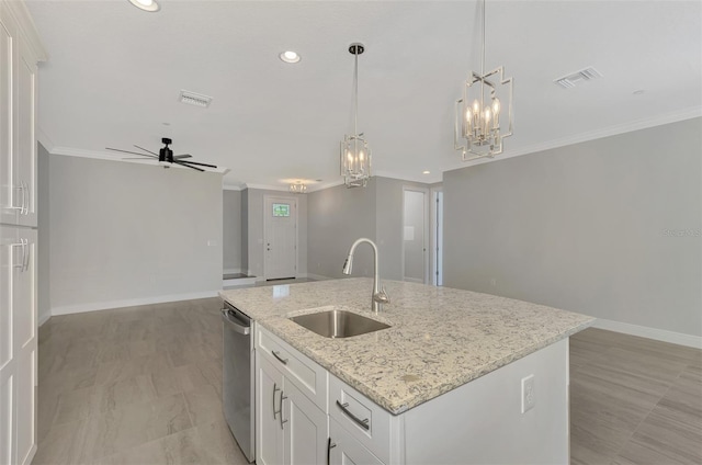 kitchen with ceiling fan with notable chandelier, an island with sink, white cabinetry, and sink