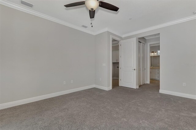 unfurnished bedroom with ceiling fan, crown molding, and carpet floors