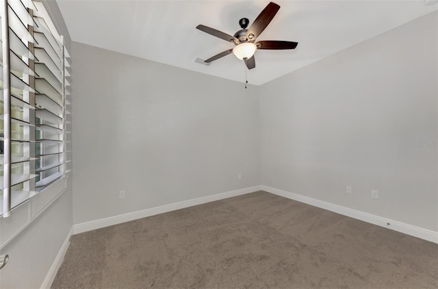 carpeted empty room with visible vents, baseboards, and a ceiling fan