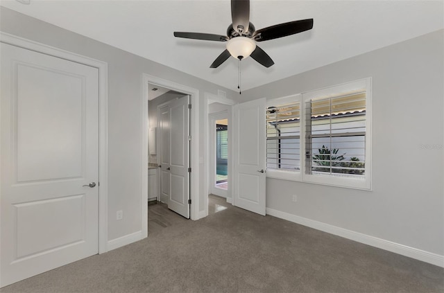 unfurnished bedroom with ensuite bath, baseboards, a ceiling fan, and carpet floors