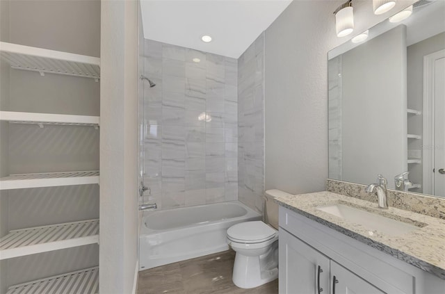 full bathroom with tiled shower / bath, toilet, and vanity