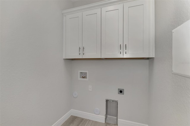 laundry room featuring gas dryer hookup, light wood-type flooring, hookup for an electric dryer, washer hookup, and cabinets