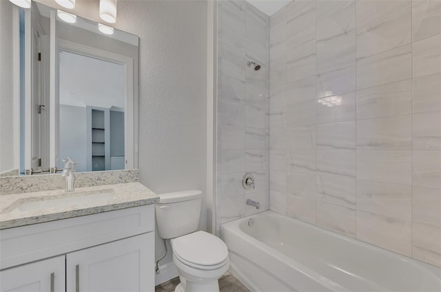 full bathroom with tiled shower / bath combo, vanity, and toilet