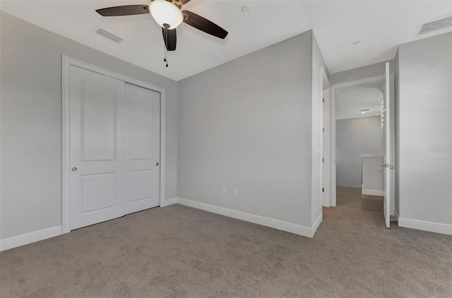 unfurnished bedroom featuring light colored carpet, ceiling fan, and a closet