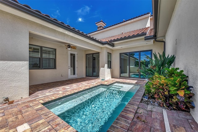 view of swimming pool featuring ceiling fan and a patio