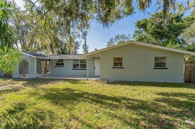 rear view of house featuring a lawn and a patio area