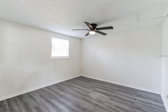 empty room with ceiling fan, dark hardwood / wood-style floors, and a textured ceiling