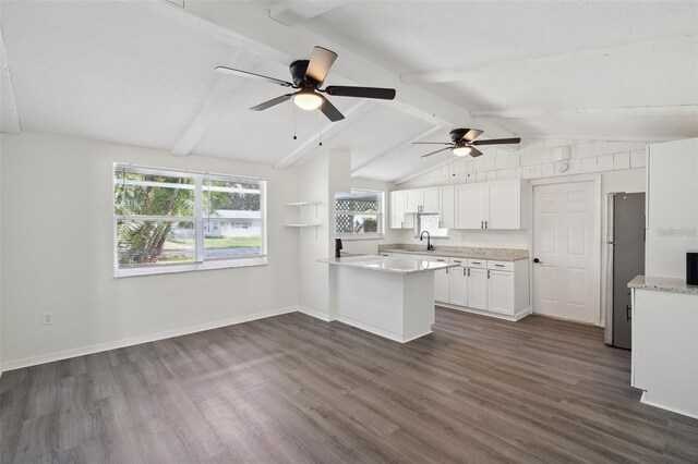 kitchen featuring dark wood-type flooring, ceiling fan, stainless steel refrigerator, and white cabinetry