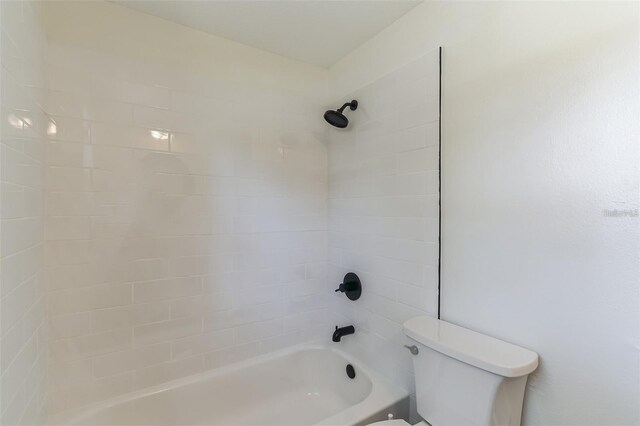 bathroom featuring tiled shower / bath and toilet