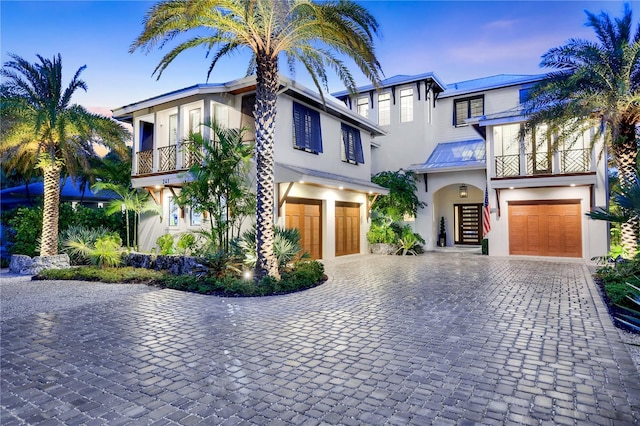 view of front of property featuring a balcony and a garage