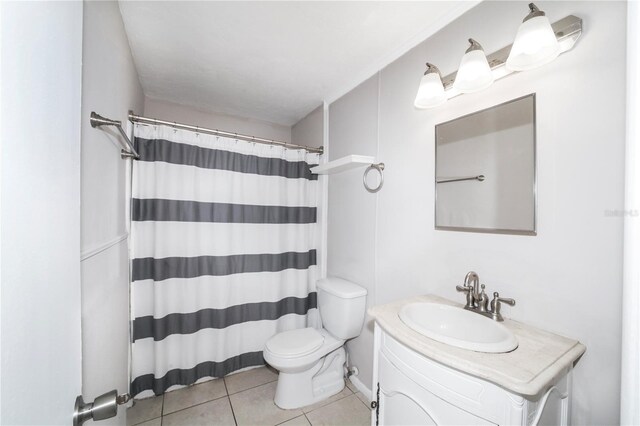 bathroom featuring tile patterned flooring, toilet, walk in shower, and vanity