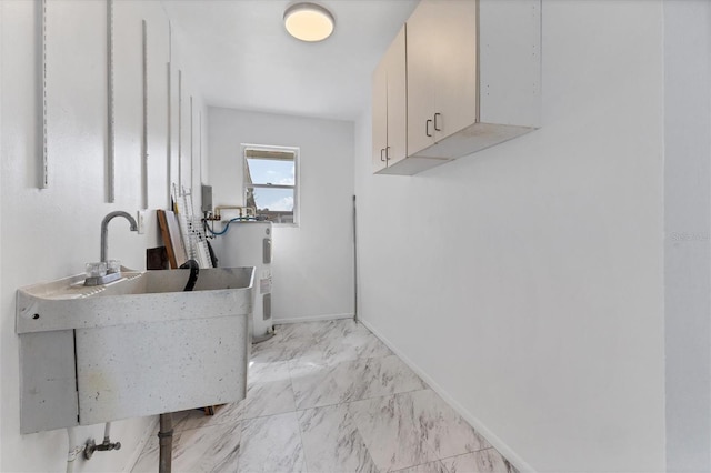 washroom featuring cabinets, sink, and water heater