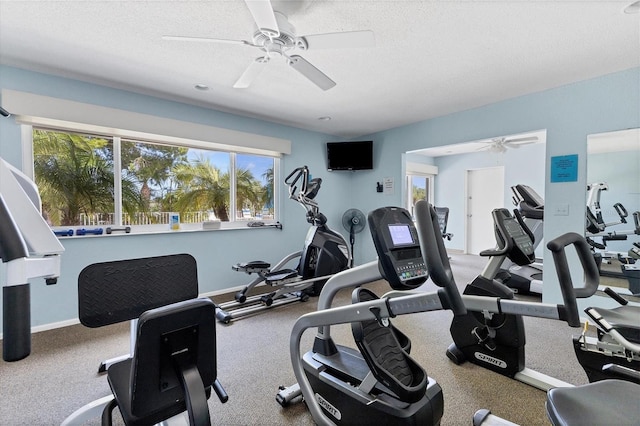 gym with ceiling fan, plenty of natural light, and a textured ceiling