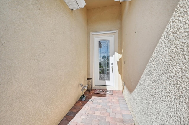 entrance to property featuring stucco siding