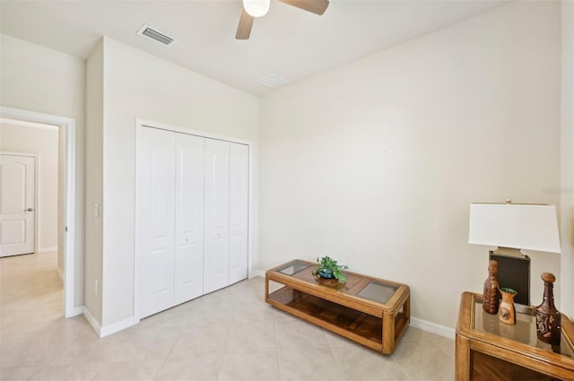 living area featuring ceiling fan, visible vents, and baseboards