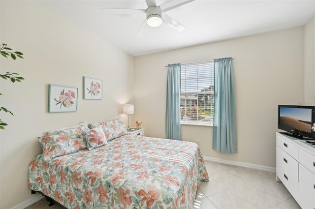 bedroom with ceiling fan, light tile patterned flooring, and baseboards