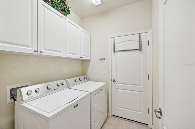 clothes washing area with cabinet space, light tile patterned floors, and independent washer and dryer