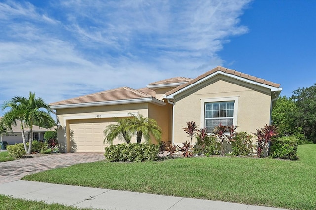 view of front of house featuring a garage, decorative driveway, a front yard, and stucco siding