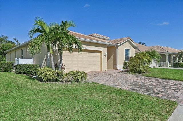 view of front facade with a garage, a front yard, and stucco siding