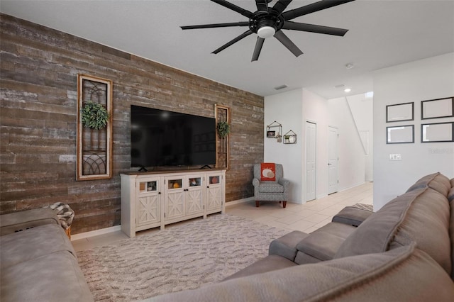 living room featuring wood walls, light tile patterned floors, and ceiling fan