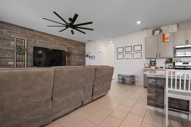 tiled living room with ceiling fan and wood walls