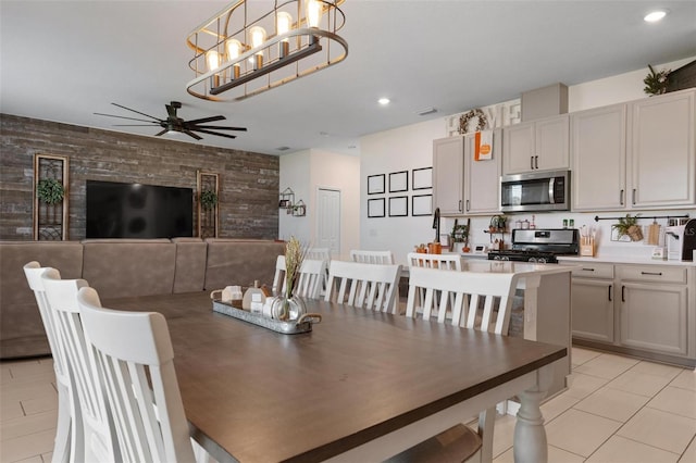 tiled dining area featuring ceiling fan with notable chandelier