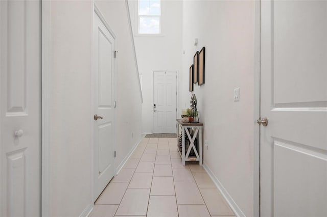 hallway featuring a skylight and light tile patterned floors